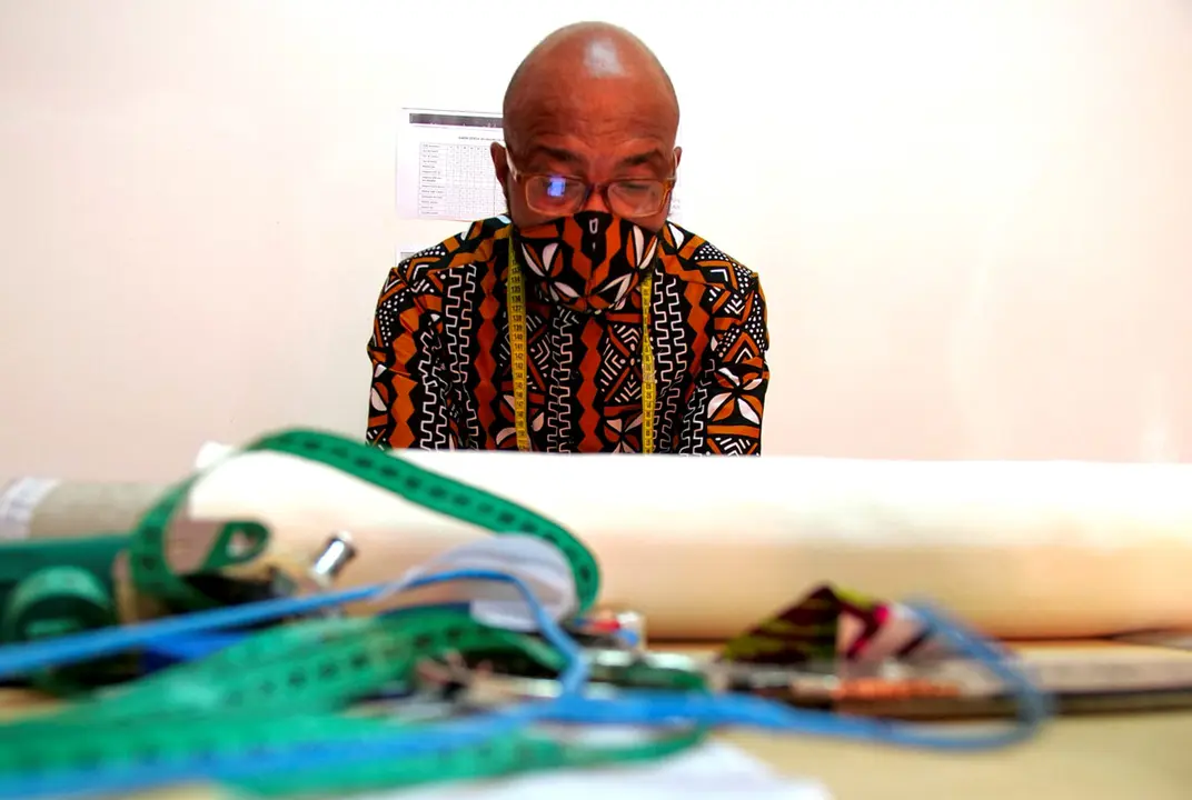 A tailor, wearing a protective face mask matching his shirt, works at the workshop of fashion designer Sophie Zinga, in Dakar, Senegal May 14, 2020. REUTERS/Christophe Van Der Perre