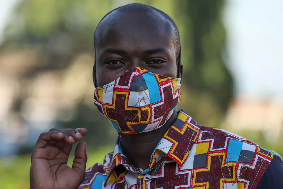 Arthur Bella N&#39;guessan, an Ivorian designer, looks on as he wears a protective face mask with colors matching his clothes, amid the coronavirus disease (COVID-19) outbreak, in Angre area of Abidjan, Ivory Coast May 13, 2020. REUTERS/Luc Gnago.