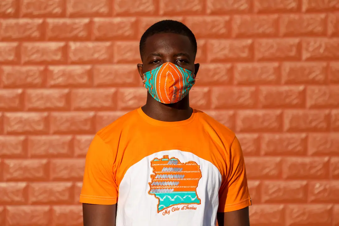 A model of Arthur Bella N&#39;guessan, an Ivorian designer, poses as he wears a protective face mask with colors matching his clothes, amid the coronavirus disease (COVID-19) outbreak, in Angre area of Abidjan, Ivory Coast May 13, 2020. REUTERS/Luc Gnago