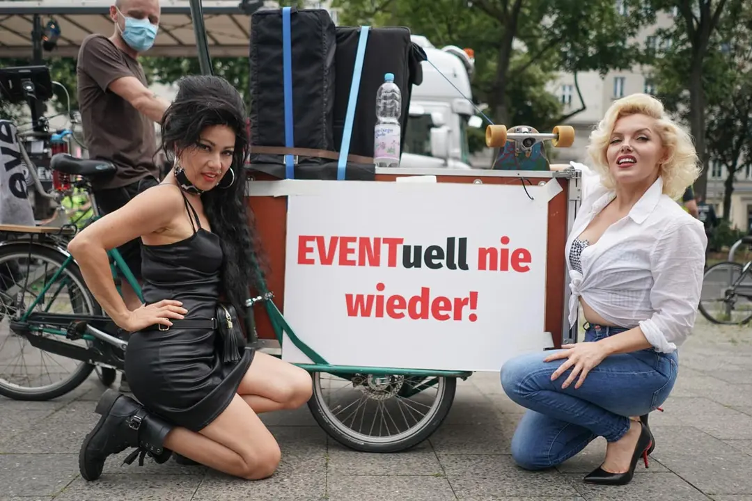 Berlin: Rachel (L) and Suzy, two performers from the Estrel Hotel, kneel next to a poster saying &#34;Possibly never again&#34; during a demonstration calling for more support for the culture and event industry during the coronavirus (COVID-19) pandemic. Photo: Jörg Carstensen/dpa