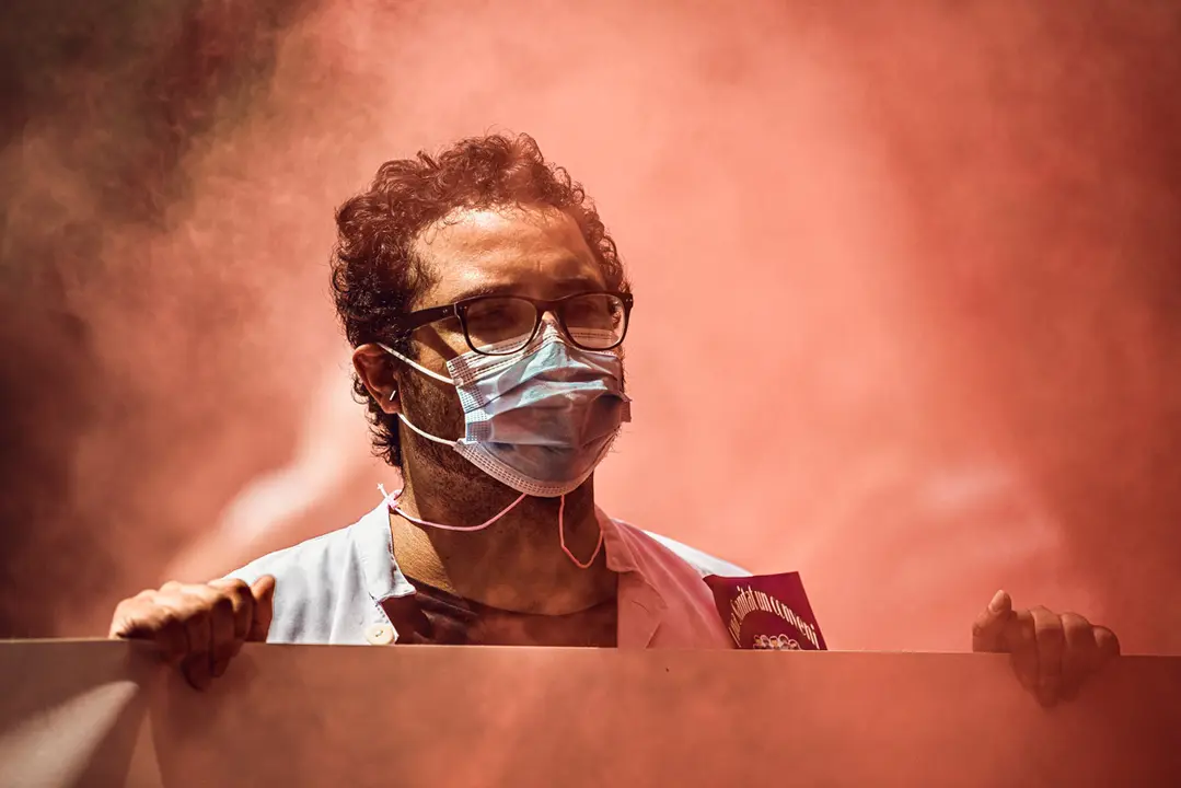 Spain, Barcelona: A member of the healthcare sector wearing a protective face mask shouts slogans during a protest against privatization and for a salary raise in front of the Catalan Parliament as Catalonia faces a rising spread of the coronavirus. Photo: Matthias Oesterle/dpa.