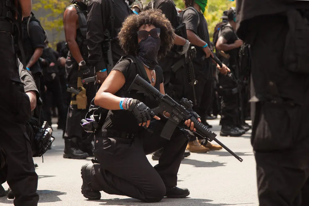 US, Louisville: A female member from Atlanta-based Black militia group Not Fucking Around Coalition (NFAC) kneels during a protest at Jefferson Park demanding justice for Breonna Taylor who was shot by Louisville Metro Police Department officers in her apartment on 13 March 2020. Photo: Leslie Spurlock/dpa.