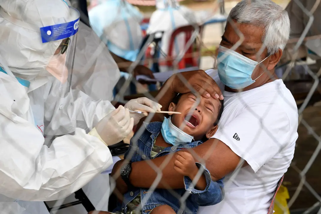 Malaysia, Alor Setar: A child cries while undergoing a coronavirus (Covid-19) test at the Napoh Health Clinic. Photo: Noraini Ahmad/dpa.