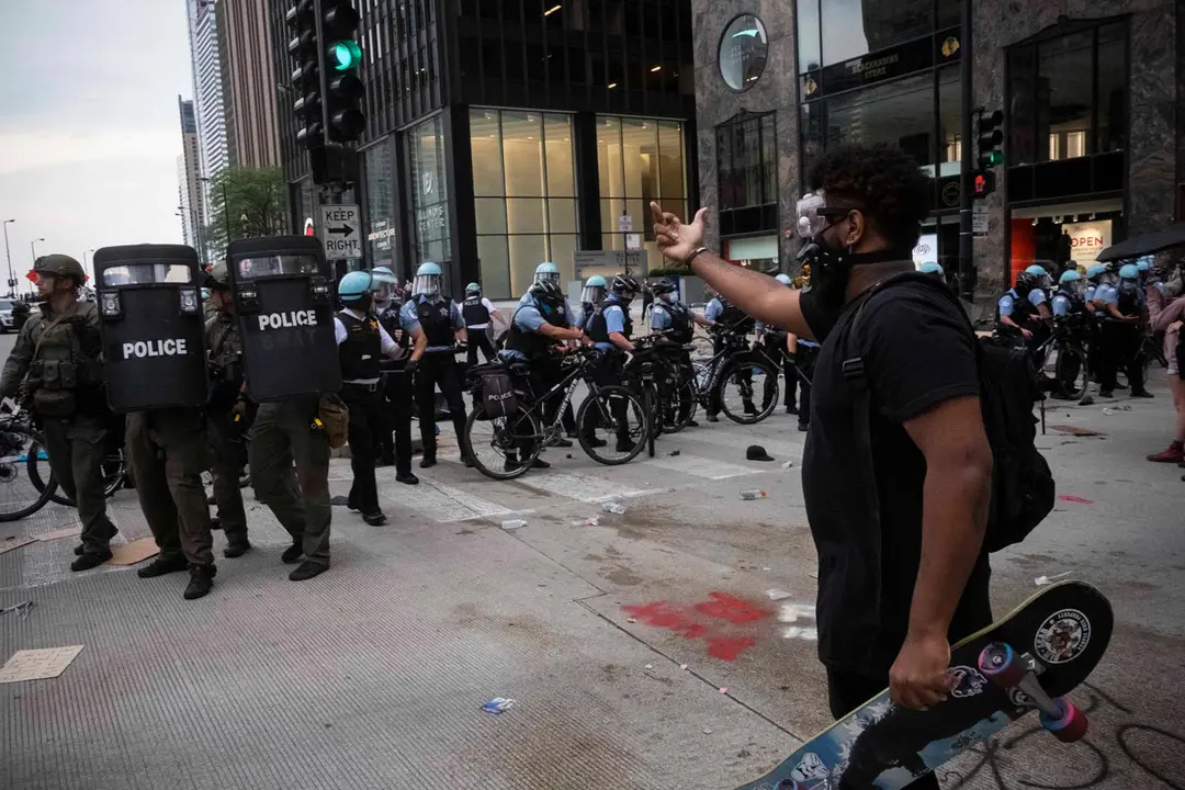 15 August 2020, US, Chicago: A protester gestures towards police officers during a protest bike ride for the Black Lives Matter Movement. Photo: Rick Majewski/dpa.