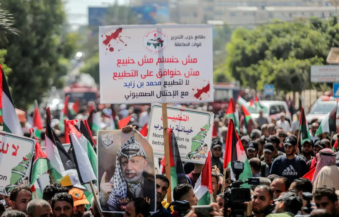 19 August 2020, Palestinian Territories, Gaza City: Palestinians hold flags and placards as they march during a protest against the rapprochement between Israel and the United Arab Emirates. On 13 August 2020, the UAE and Israel have agreed to establish full diplomatic ties, make the UAE the first Gulf Arab country to establish diplomatic ties with Israel and only the third Arab nation to do so. Photo: Mahmoud Issa/dpa.