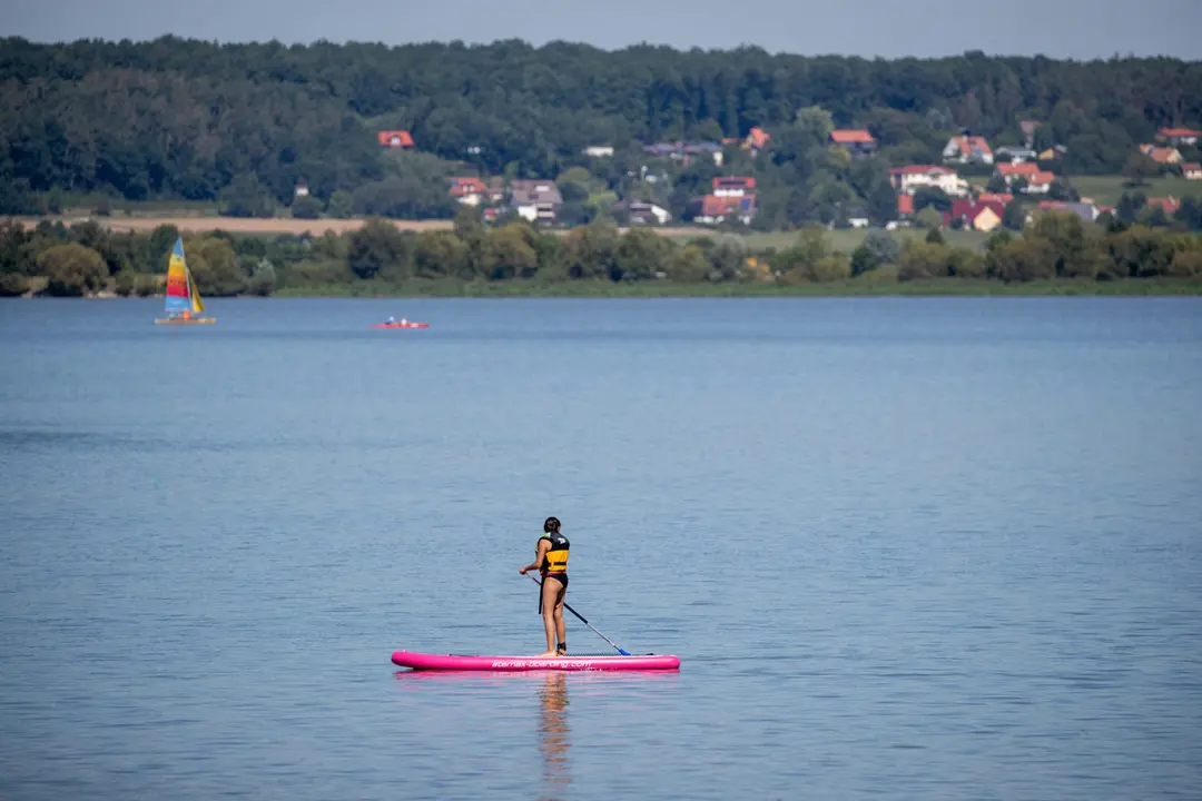 21 August 2020, Bavaria, Altmuehlsee: A woman glides on a Stand Up Paddle (SUP) over the Altmuehlsee. Photo: Daniel Karmann/dpa.