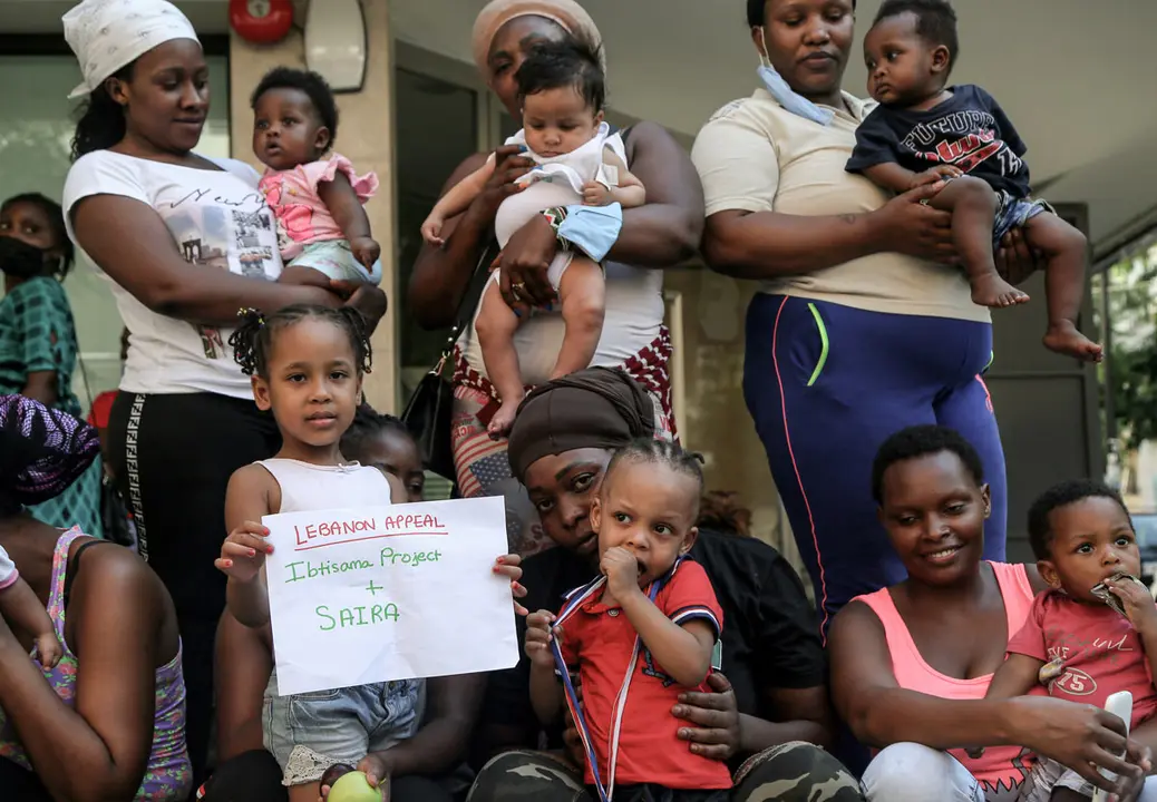 24 August 2020, Lebanon, Beirut: Kenyan domestic workers and their children gather outside the Kenyan consulate in Beirut to finalize their documentation so that they can return home. Thousands of foreign workers in Lebanon, some without legal documentation, are out of work amid the country’s dire economic situation, and remain stranded amid border closures as a result of the coronavirus (COVID-19 ) pandemic. Additionally, their plight has worsened by the impact of the 04 August 2020 massive explosion at the Beirut sea port. Photo: Marwan Naamani/dpa.