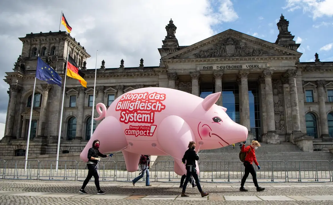 Activists of the campaign organisation Campact carry a huge inflatable pig with the inscription &#34;Stop the cheap meat system&#34; take part in a protest against Germany&#39;s largest slaughterhouse Toennies and how they did manage the coronavirus crisis. Photo: Bernd von Jutrczenka/dpa.