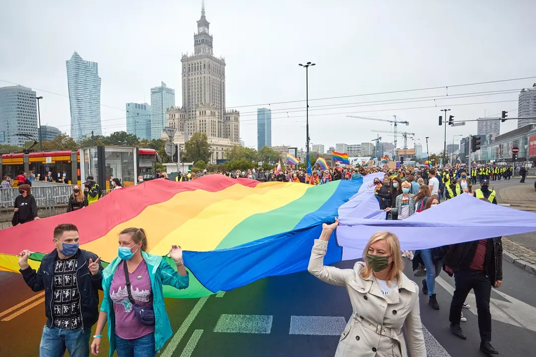 30 August 2020, Poland, Warsaw: Participants wave a huge rainbow flag during a demonstration against hatred towards LGBT people and violence against homosexuals in Warsaw. Photo: Hubert Mathis/dpa.