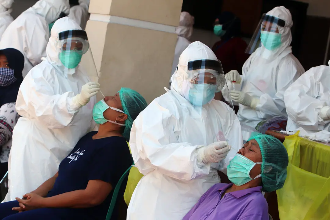 15 September 2020, Indonesia, Surabaya: Medical workers take nasal swab samples from women at a Public Health Center during a coronavirus testing campaign. Photo: Budiono/dpa.
