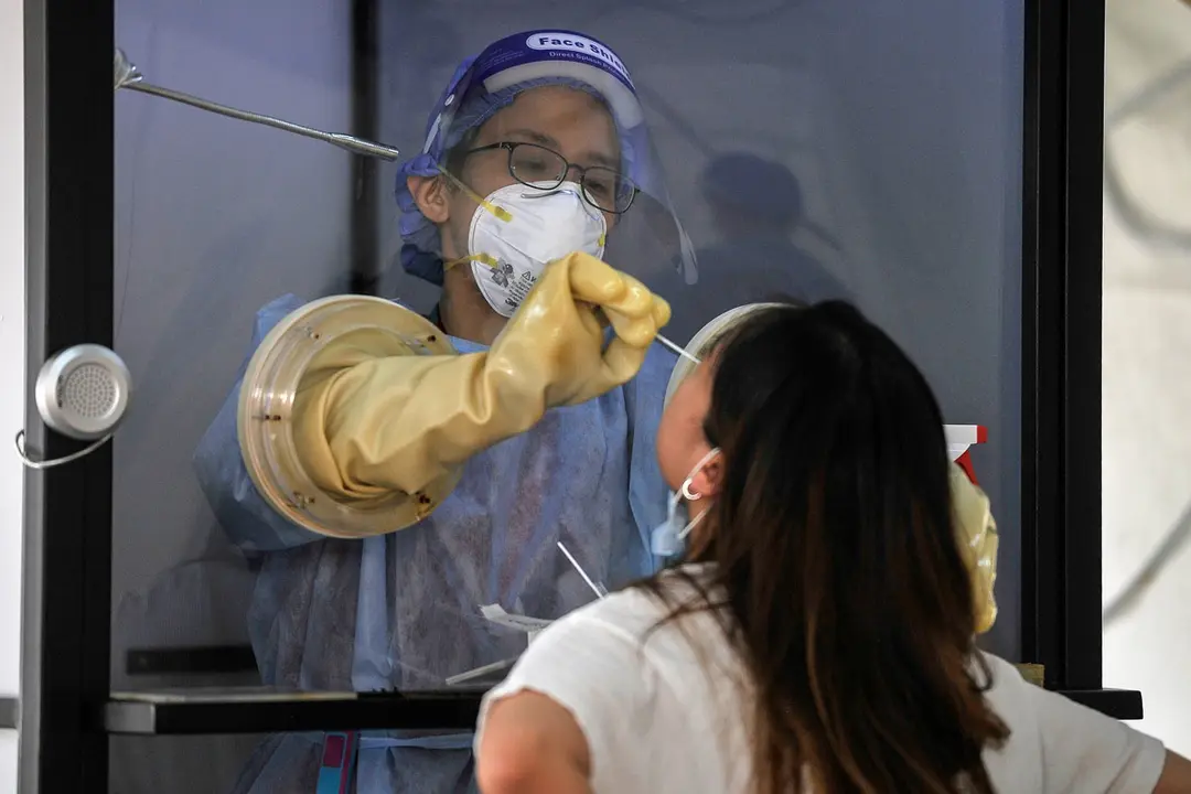 08 October 2020, Malaysia, Petaling Jaya: A health worker stands inside a mobile medical chamber as he takes a swab from a woman for coronavirus (COVID-19) at Sunway Medical Centre. Photo: Amirul Azmi/dpa.