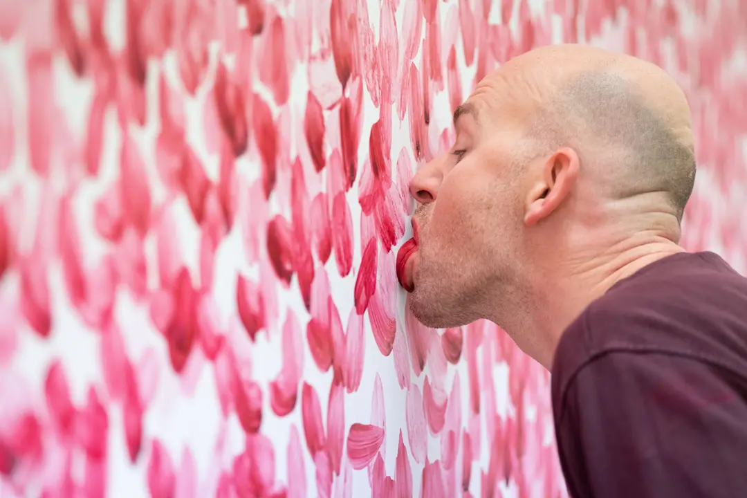 FILED - 08 October 2020, Lower Saxony, Wolfsburg: Benjamin Houlihan paints a mural with his tongue at Wolfsburg Art Museum by using a mixture of curd cheese and food colours. Photo: Peter Steffen/dpa.