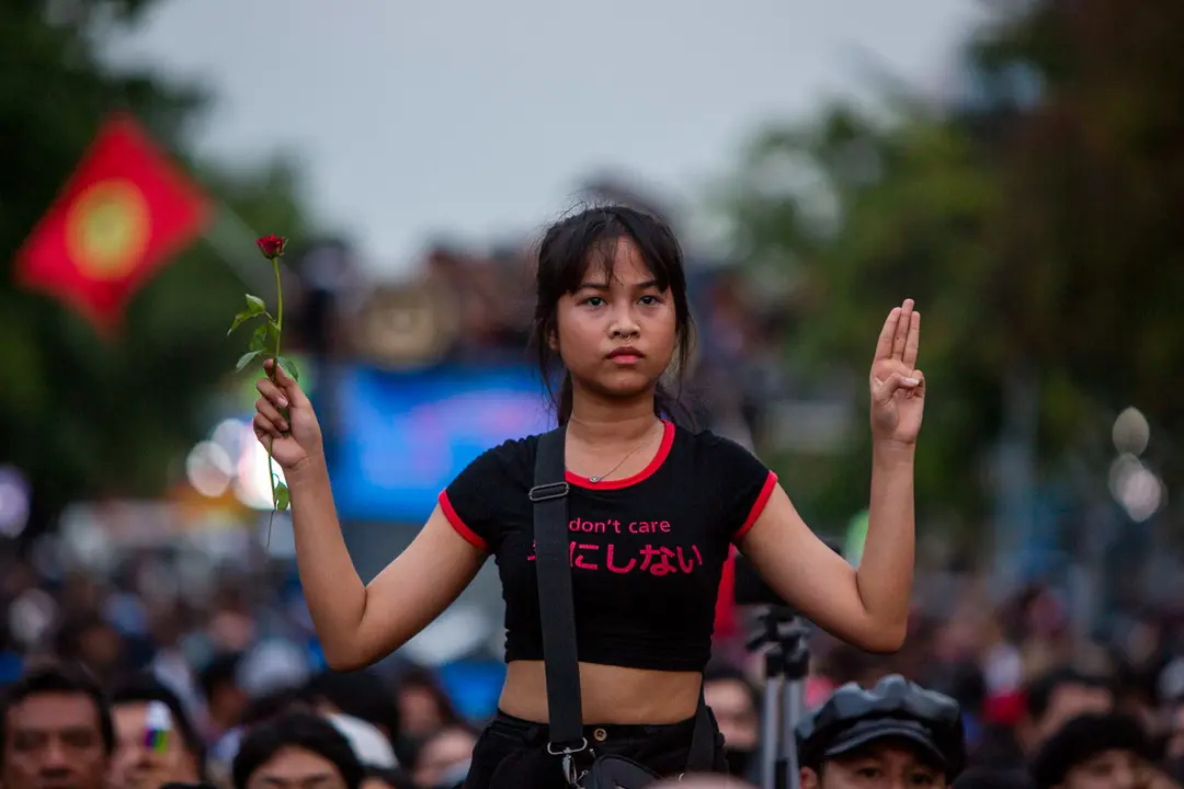 14 October 2020, Thailand, Bangkok: A pro-democracy demonstrator holding a rose does a three-fingered salute during a march towards Government House to demand the resignation of Prime Minister Prayuth Chan-ocha&#39;s government. Photo: Adryel Talamantes/dpa.