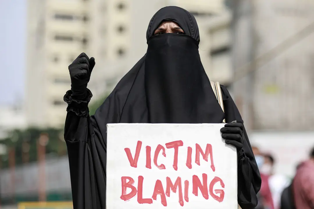 21 October 2020, Bangladesh, Dhaka: A Bangladeshi student dressed in black holds a placard that reads &#39;Victim Blaming&#39; during a protest against recent alleged rape and torture of a woman in Dhaka. Photo: Suvra Kanti Das/dpa.