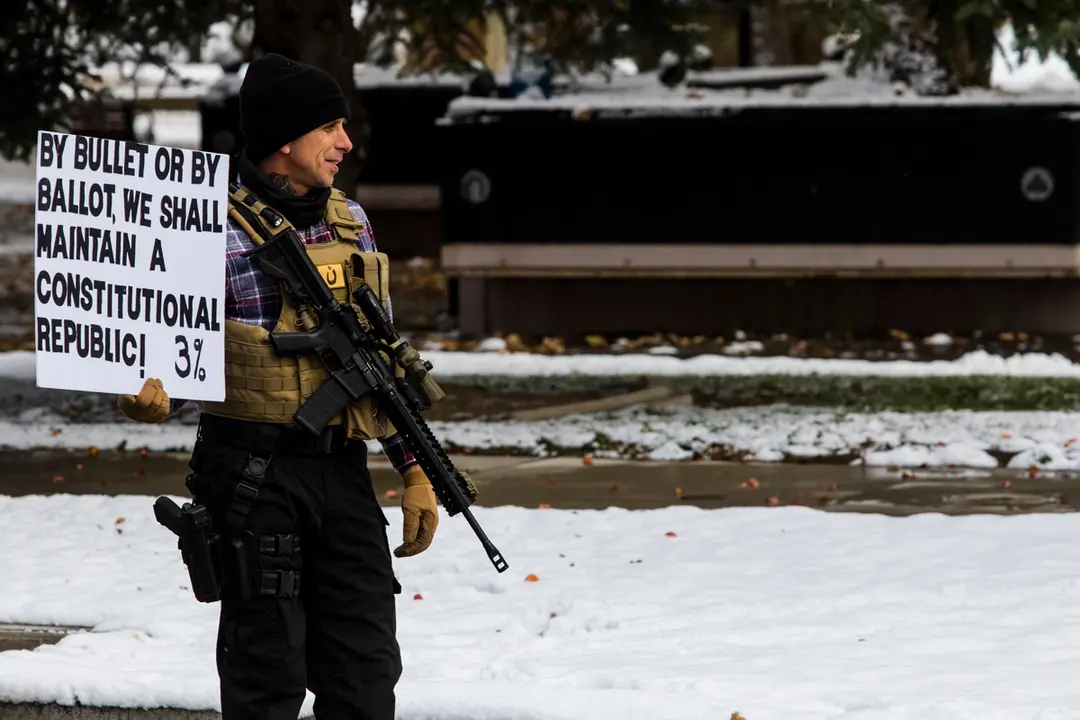 08 November 2020, US, Carson City: A man with an AR-15 style rifle holds a placard during a protest by Trump supporters against what they call election Fraud. Photo: Ty O&#39;neil/dpa.