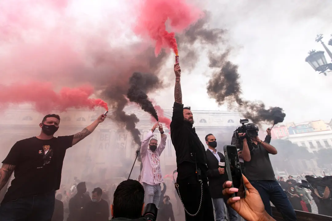 14 November 2020, Portugal, Lisbon: People hold smoke flares during a protest against the restrictions on restaurants, nightclubs and small shops due to the Coronavirus (Covid 19) pandemic. Photo: Hugo Amaral/SOPA Images via ZUMA Wire/dpa