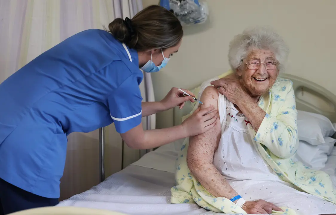 09 December 2020, England, Liverpool: Ethel Jean Murdoch (R), 95-year-old receives a coronavirus vaccination at Aintree University Hospital of the NHS Foundation Trust. Photo: Gareth Jones/PA Media/dpa.