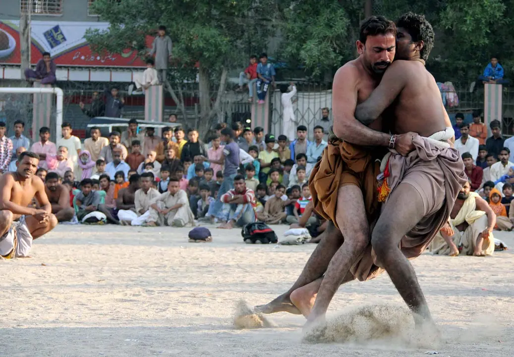 14 December 2020, Pakistan, Karachi: Wrestlers fight during a traditional Sindhi Malakhra wrestling tournament. Photo: -/PPI via ZUMA Wire/dpa.