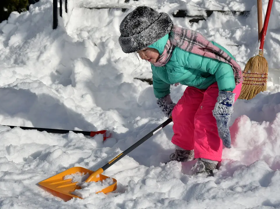17 December 2020, US, Wilkes-Barre: A bundled up girl tries to help shovel snow outside of her Grandmothers home after a snowstorm. Photo: Aimee Dilger/SOPA Images via ZUMA Wire/dpa