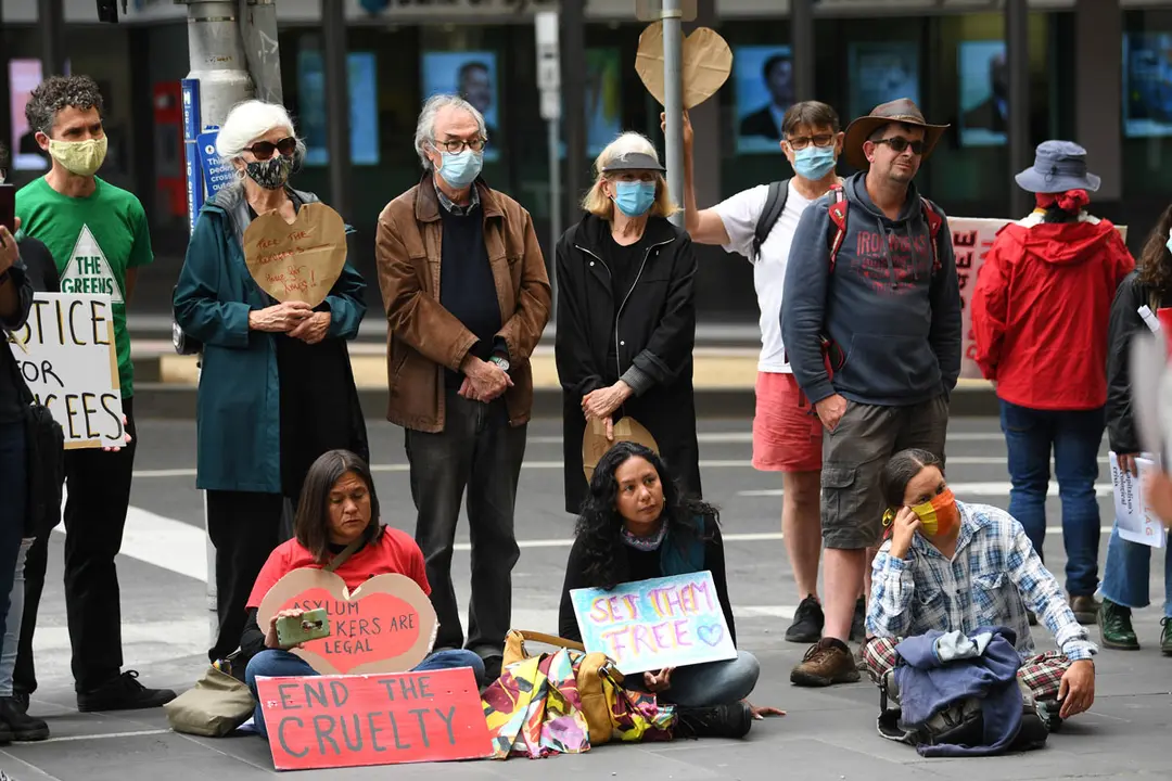 21 December 2020, Australia, Melbourne: Protesters take part in a protest to support refugees outside the Department of Home Affairs. About 60 refugees have been transferred under police guard from a hotel in Melbourne's north to a former quarantine hotel in the city's inner suburbs. Photo: James Ross/AAP/dpa