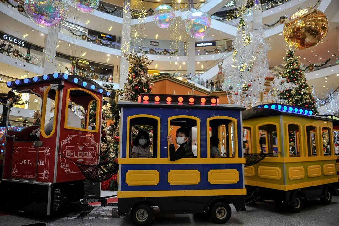 Kuala Lumpur (Malaysia): Children take a ride in the mini train inside a mall which is decorated for Christmas celebrations. Photo: Amirul Azmi/dpa.