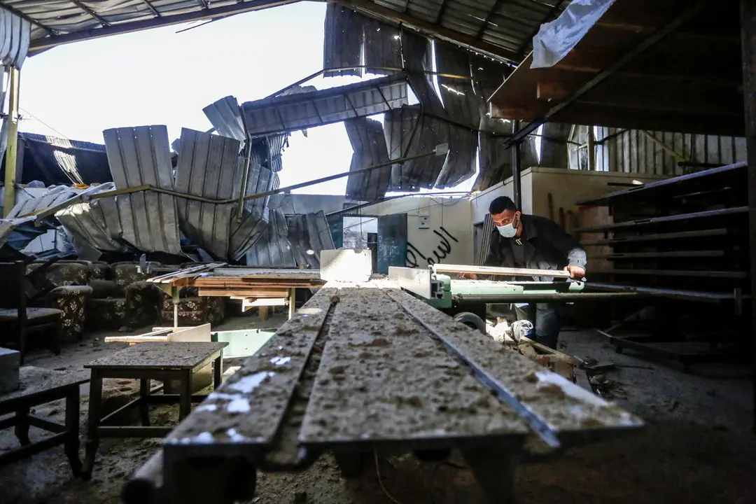 26 December 2020, Palestinian Territories, Gaza City: A Palestinian man inspects the damage at a workshop, after Israeli warplanes carried out airstrikes on the Gaza strip. Israel's military said early Sunday it had struck Hamas targets in the Gaza Strip in response to rockets fired from Gaza towards Israel. Photo: Mahmoud Issa/Quds Net News via ZUMA Wire/dpa