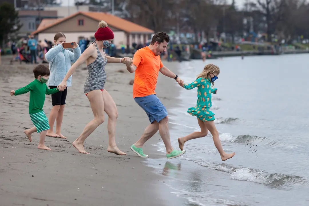 01 January 2021, US, Seattle: Swimmers run into the frigid waters of Puget Sound during the annual West Seattle Polar Bear Swim. Photo: Paul Christian Gordon/ZUMA Wire/dpa