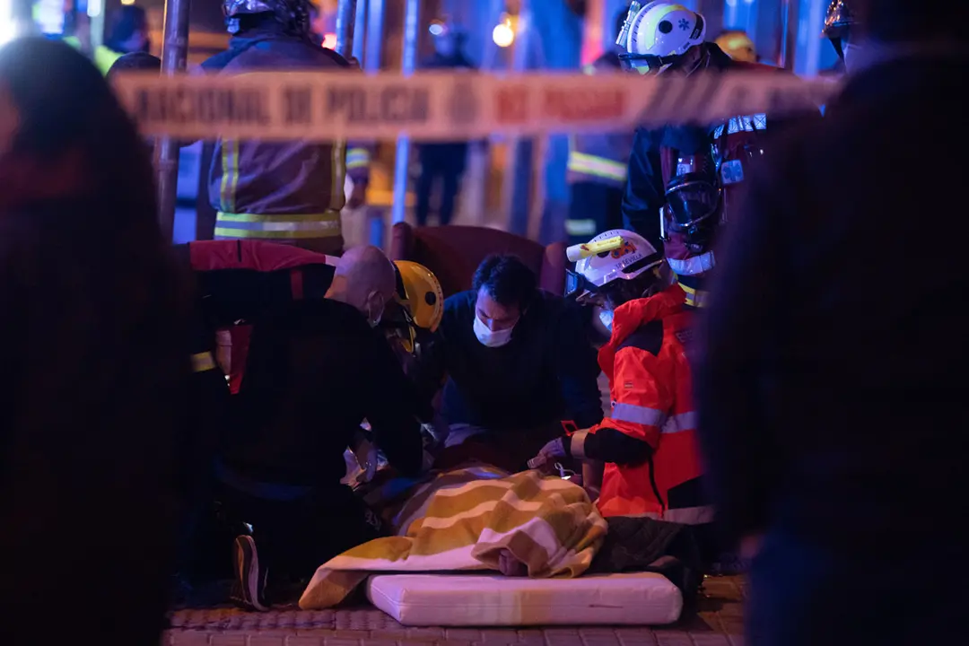 06 January 2021, Spain, Seville: Paramedics and rescue team care for an elderly person in the street before being transferred to a hospital after a fire in an old people's nursing home. Photo: Eduardo Briones/EUROPA PRESS/dpa