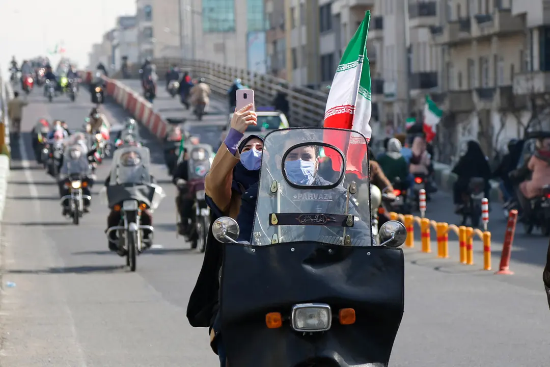10 February 2021, Iran, Tehran: People on motorbikes take part in a drive-in rally to celebrate the 42nd anniversary of the 1979 Islamic Revolution. Photo: Amin Monfared/ZUMA Wire/dpa
