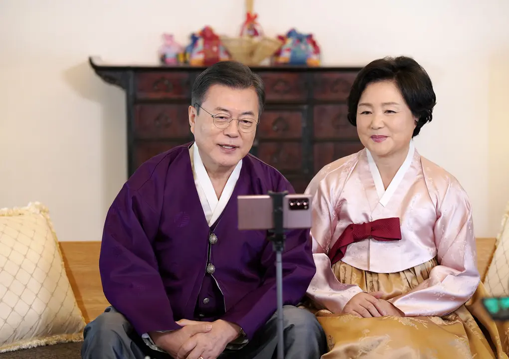 12 February 2021, South Korea, Seoul: South Korean President Moon Jae-in (L) and his wife, Kim Jung-sook, wearing the traditional Korean dress hanbok, send well wishes for Lunar New Year's Day through a smartphone at Cheong Wa Dae. Photo: -/YNA/dpa