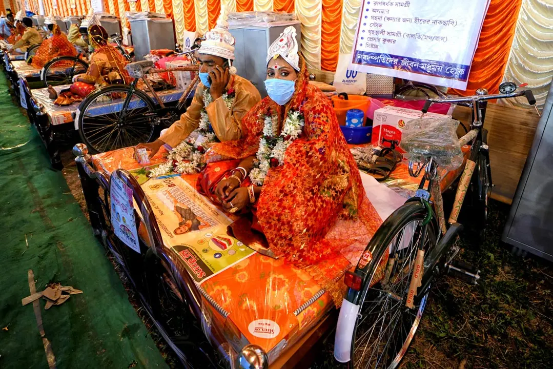 14 February 2021, India, Kolkata: Couples take part in a mass wedding ceremony, organised by the NGO "Aloy Phera" for 70 couples from different religions in Kolkata. The mass wedding ceremony is held on Valentine's Day for couples from various religions and communities who lack the basic financial support in their families, to spread the message of love and social harmony. Photo: Avishek Das/SOPA Images via ZUMA Wire/dpa