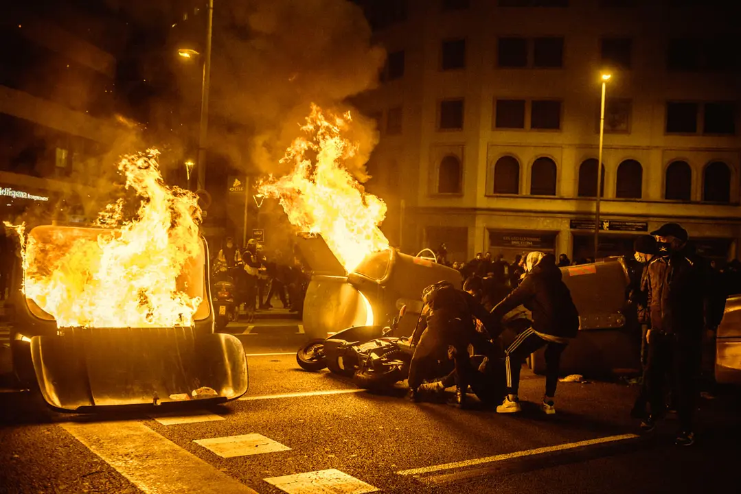 16 February 2021, Spain, Barcelona: Protesters burn barricades made out of dumpsters during the clash with police force following a protest against the imprisonment of Spanish rapper Pau Rivadulla Duro, known as Pablo Hasel. The Spanish police arrested Hasel on Tuesday after a court had sentenced him to nine month in prison for insulting the monarchy and glorifying violence. Photo: Matthias Oesterle/ZUMA Wire/dpa