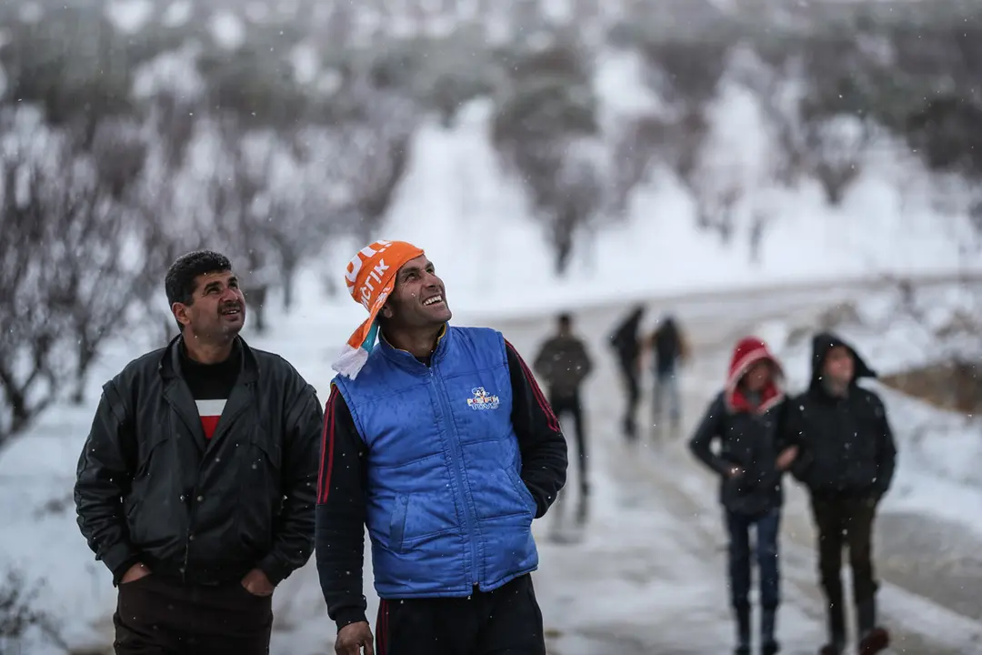 17 February 2021, Syria, Arnaba: People watch as snow falls on the village of Arnaba. Photo: Anas Alkharboutli/dpa