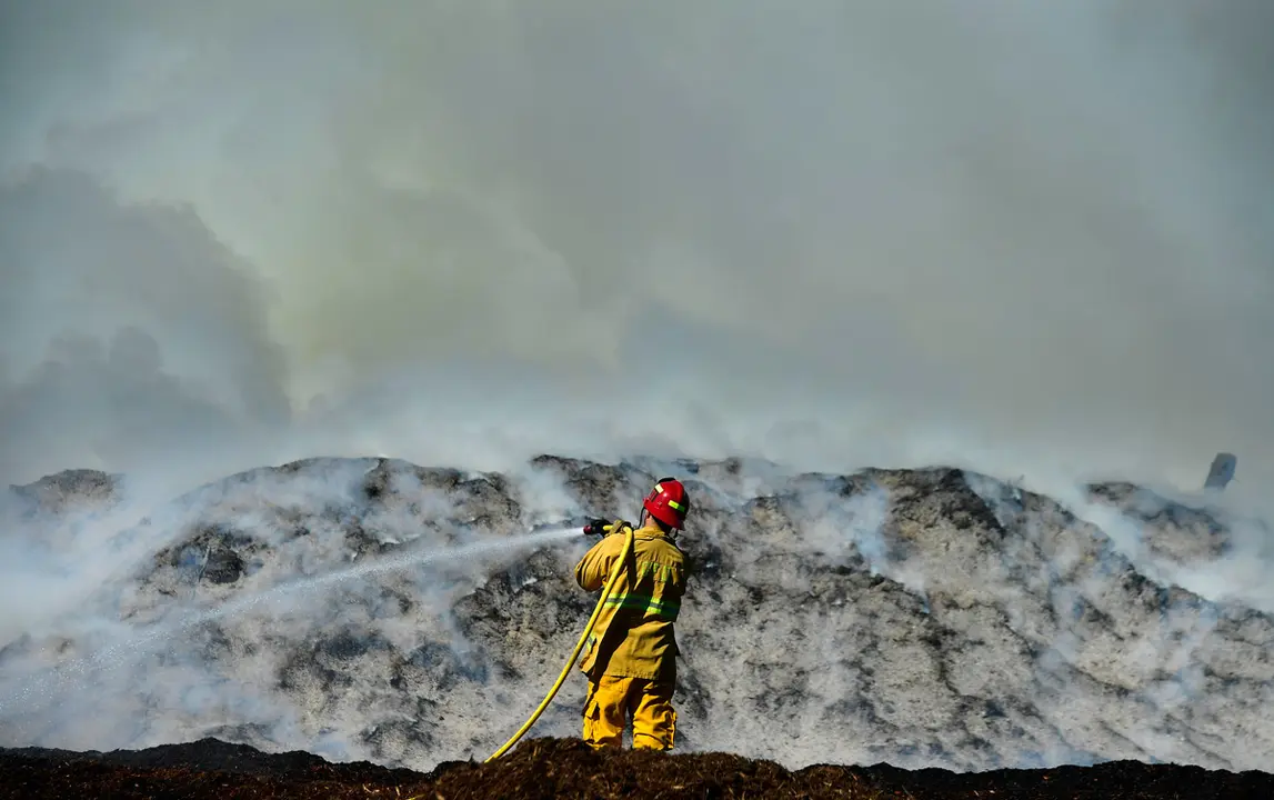 18 February 2021, US, Ontario: A firefighter works to extinguish a mulch fire at RWP Recycled Wood Products & Landscape Material in Chino Avenue in Ontario. Photo: Will Lester/Orange County Register via ZUMA/dpa