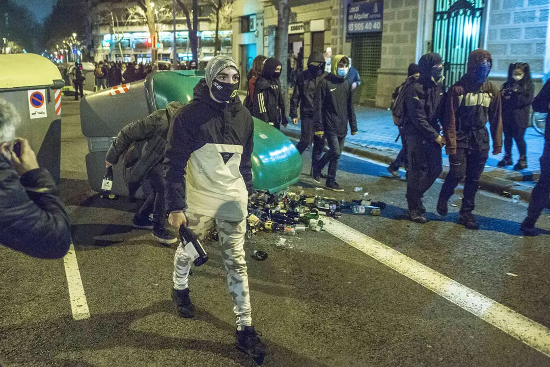 23 February 2021, Spain, Barcelona: Protesters hold glass bottles during a protest against the imprisonment of Spanish rapper Pau Rivadulla Duro, known as Pablo Hasel. The Spanish police arrested Hasel after a court had sentenced him to nine-month in prison for insulting the monarchy and glorifying violence. Photo: Thiago Prudencio/SOPA Images via ZUMA Wire/dpa