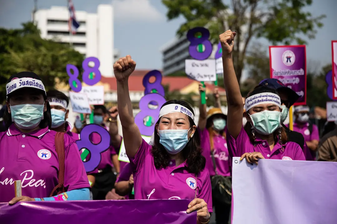 08 March 2021, Thailand, Bangkok: Women hold placards during a march on International Women's Day to call attention to laws on harassment and violence in the workplace or maternity protection. Photo: Andre Malerba/ZUMA Wire/dpa