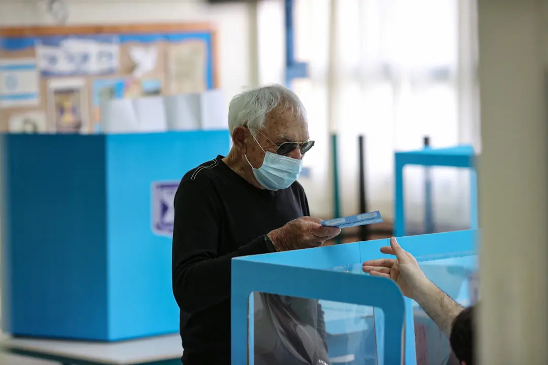 23 March 2021, Israel, Tel Aviv: A man registers before casting his vote at a polling station during the Israeli Parliamentary election. Photo: Ilia Yefimovich/dpa
