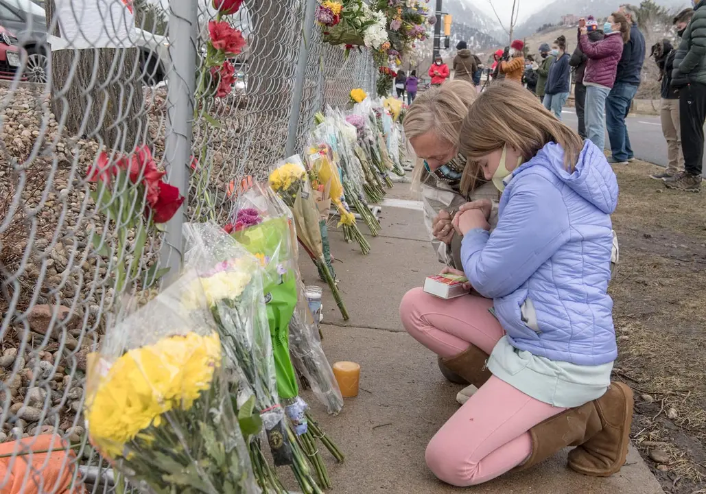23 March 2021, US, Boulder: People mourn at a makeshift memorial outside the King Soopers grocery store where 10 people were killed by a gunman during a mass shooting. Photo: Pj Heller/ZUMA Wire/dpa