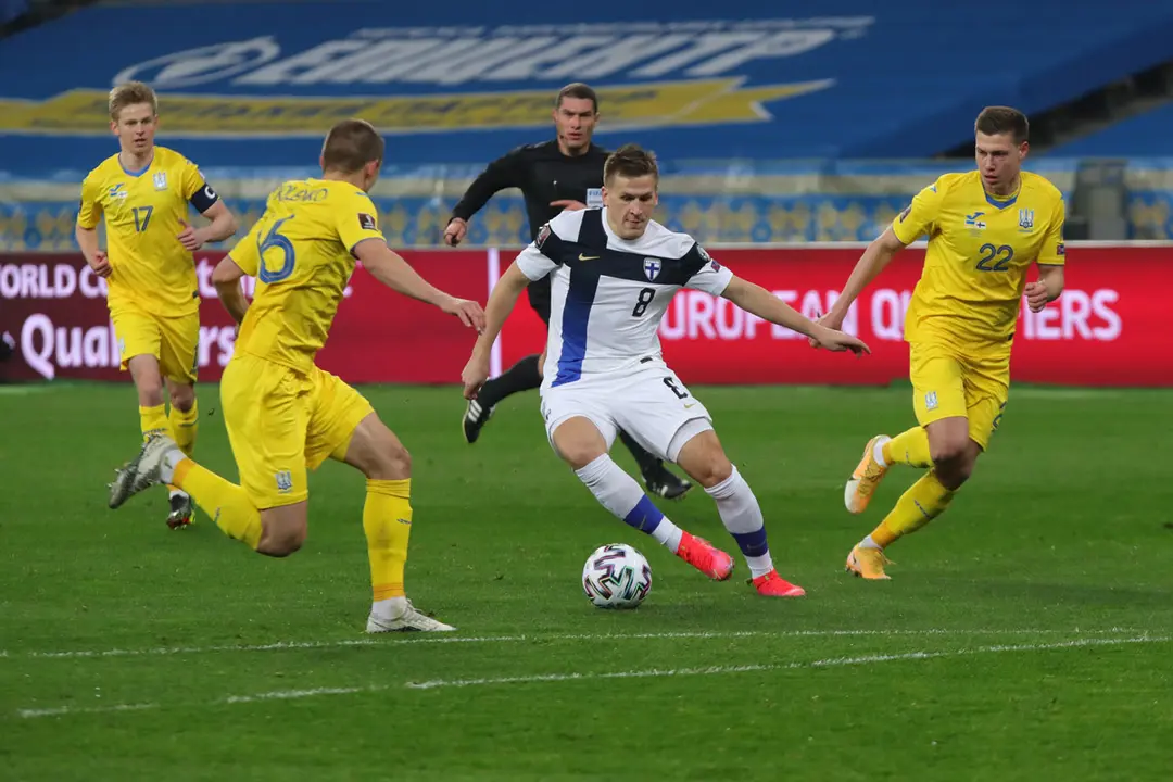 28 March 2021, Ukraine, Kiev: Finland's Robin Lod (C) battles for the ball with Ukraine's Vitaliy Mykolenko (L) and Mykola Matviyenko (R) during the FIFA 2022 World Cup European Qualifiers Group D football match between Ukraine vs Finland at the National Sports Complex. Photo: -/Ukrinform/dpa