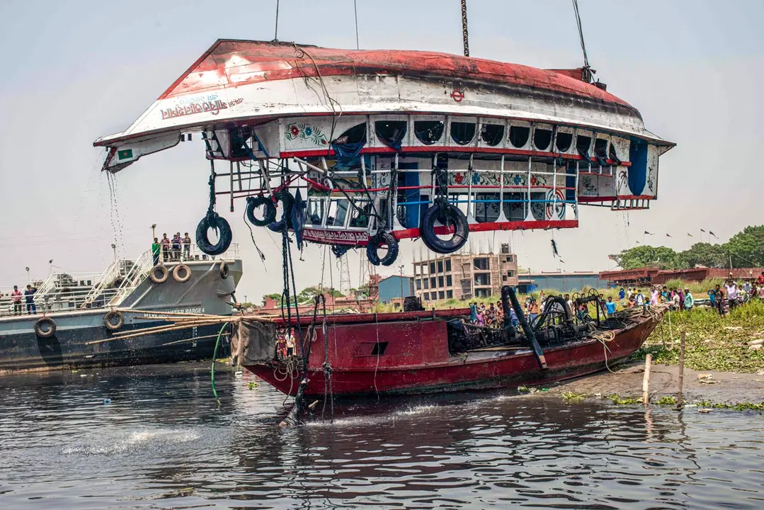 05 April 2021, Bangladesh, Narayanganj: A rescue ship pulls out a capsized boat from Shitalakshya River. A Bangladeshi ferry capsized after colliding with a cargo vessel on Sunday in Shitalakkhya river south of the capital Dhaka, leaving at least 26 people dead and a few still missing. Photo: Ziaul Haque Oisharjh/SOPA Images via ZUMA Wire/dpa