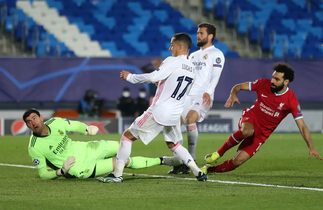 06 April 2021, Spain, Madrid: Liverpool's Mohamed Salah (R) scores their side's first goal of the game during the UEFA Champions League quarter-final first leg soccer match between Real Madrid and Liverpool at the Alfredo Di Stefano Stadium. Photo: Isabel Infantes/PA Wire/dpa