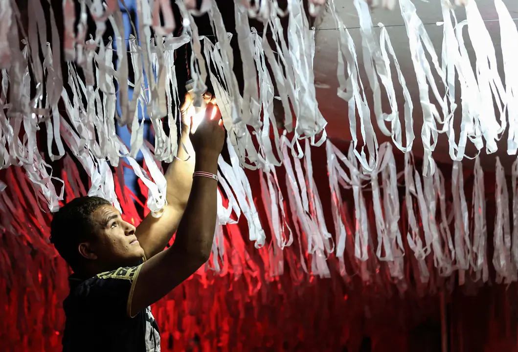 11 April 2021, Egypt, Giza: A man hangs Ramadan decorations in a street at al-Baragel village. Muslims around the world prepare to celebrate the holy month of Ramadan, the ninth and holiest month of the Islamic calendar, in which believers refrain from eating, drinking and smoking from dawn to dusk. Photo: Mahmoud Bakkar/dpa