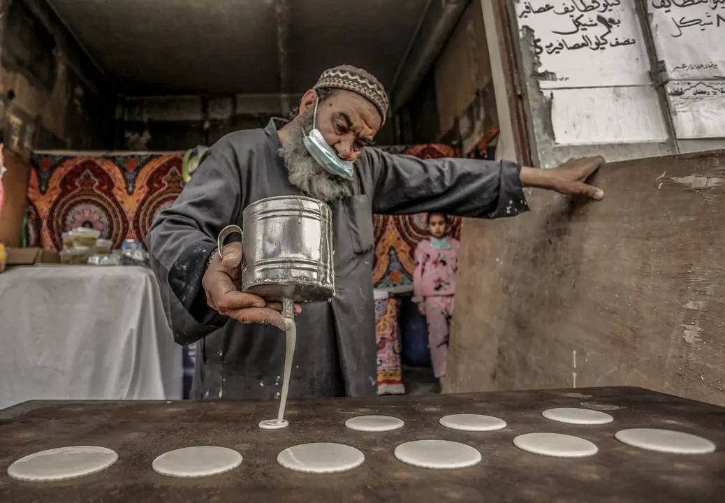 Gaza (Palestine): A Palestinian man prepares the traditional pancakes known as "Qatayef" during the Muslim holy fasting month of Ramadan. Photo: Mahmoud Issa/dpa.