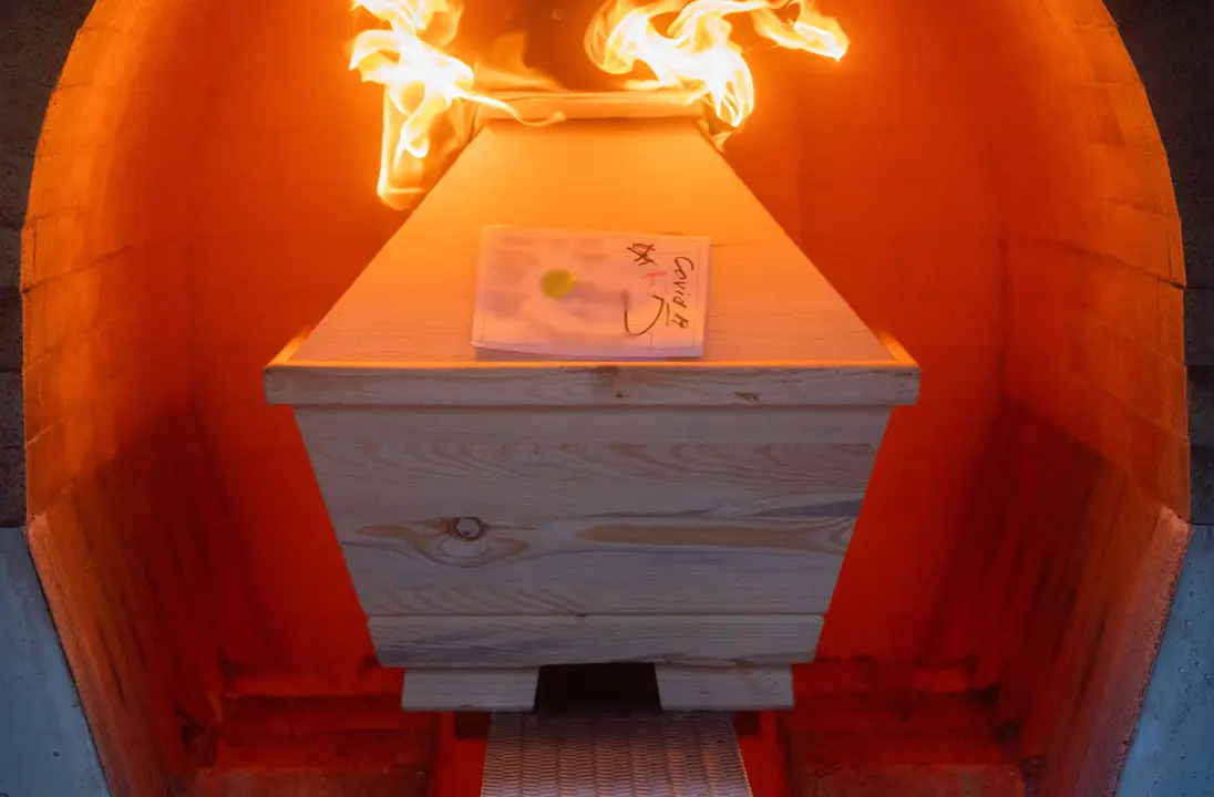 28 April 2021, Lower Saxony, Giesen: A coffin labelled "SARS-CoV-2 positive Corona" is cremated in an oven at the Hildesheim crematorium. More than 5200 people in Lower Saxony have died in connection with Corona since the beginning of the pandemic. Photo: Julian Stratenschulte/dpa