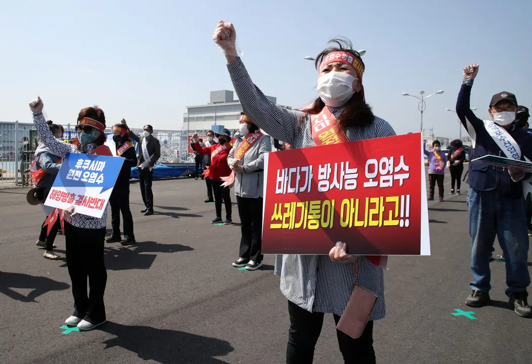 30 April 2021, South Korea, Seoul: Protestors from the fisheries industry hold placards at a port in Mokpo-si during a rally against Japan's radioactive water discharge. The National Federation of Fisheries Cooperatives organized the rally to criticize Japan for its decision to discharge water containing radioactive materials stored at the Fukushima nuclear power plant into the ocean. Photo: -/yonhap/dpa