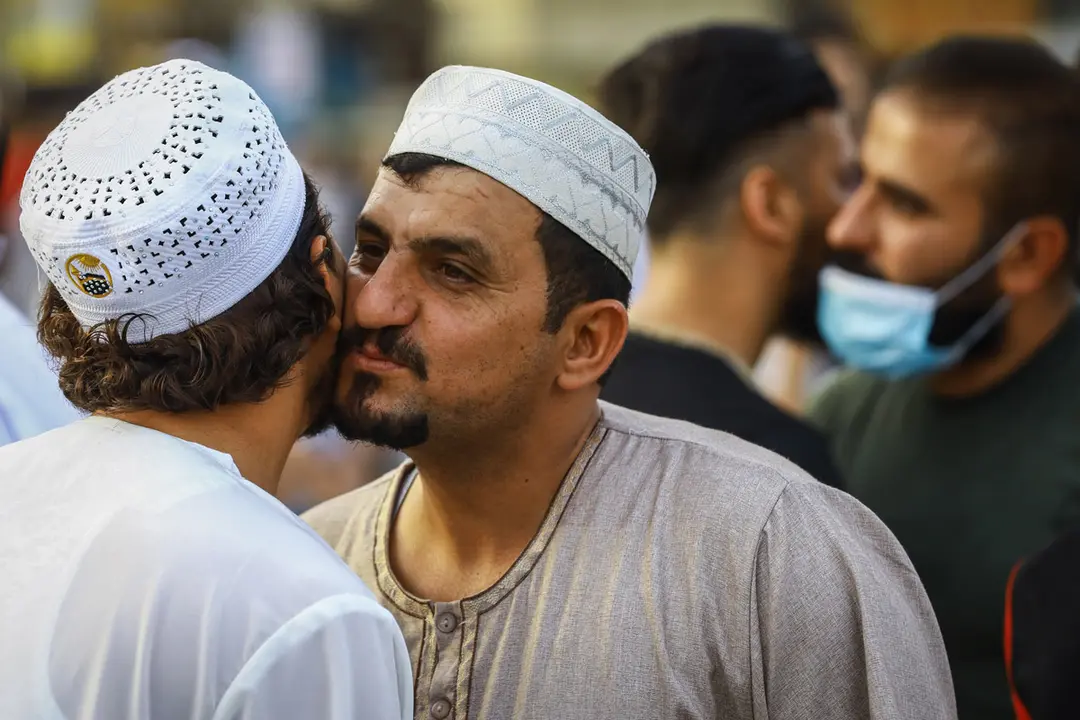 13 May 2021, Iraq, Baghdad: People greet each other after Eid al-Fitr prayer near the shrine of Abu Hanifa al-Numan in the Al-Adhamiyah district in Baghdad. Eid al-Fitr marks the end of the holy Islamic fasting month of Ramadan. Photo: Ameer Al Mohammedaw/dpa