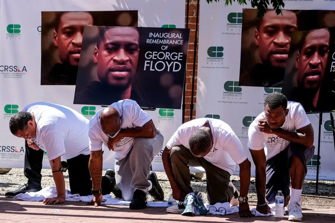 25 May 2021, US, Los Angeles: People pray and take a knee for nine minutes and 29 seconds in memory of George Floyd on the first anniversary of his death. Photo: Ringo Chiu/ZUMA Wire/dpa