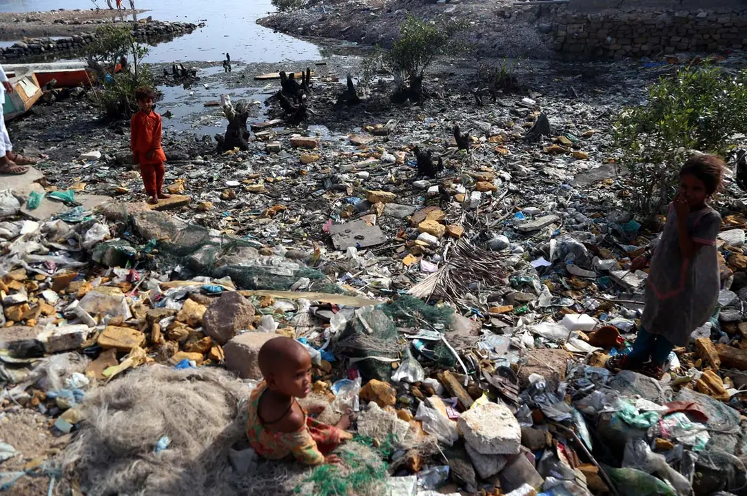 04 June 2021, Pakistan, Karachi: Garbage collectors search through a mountain of trash for useful items to sell to support themselves and their families. Photo: -/PPI via ZUMA Wire/dpa
