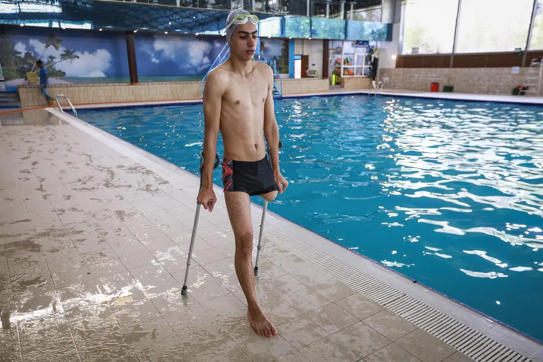 10 June 2021, Iraq, Najaf: Mortada Shaker Mahmoud, an Iraqi amputee swimmer, leaves the swimming pool after a training session. Mortada Mahmoud, who has lost his leg in an explosion carried out by the Islamic State (IS) in Mosul in 2014, will compete in the 2020 Summer Paralympic Games, scheduled to be held between 24 August and 5 September in Japan. Photo: Ameer Al Mohammedaw/dpa
