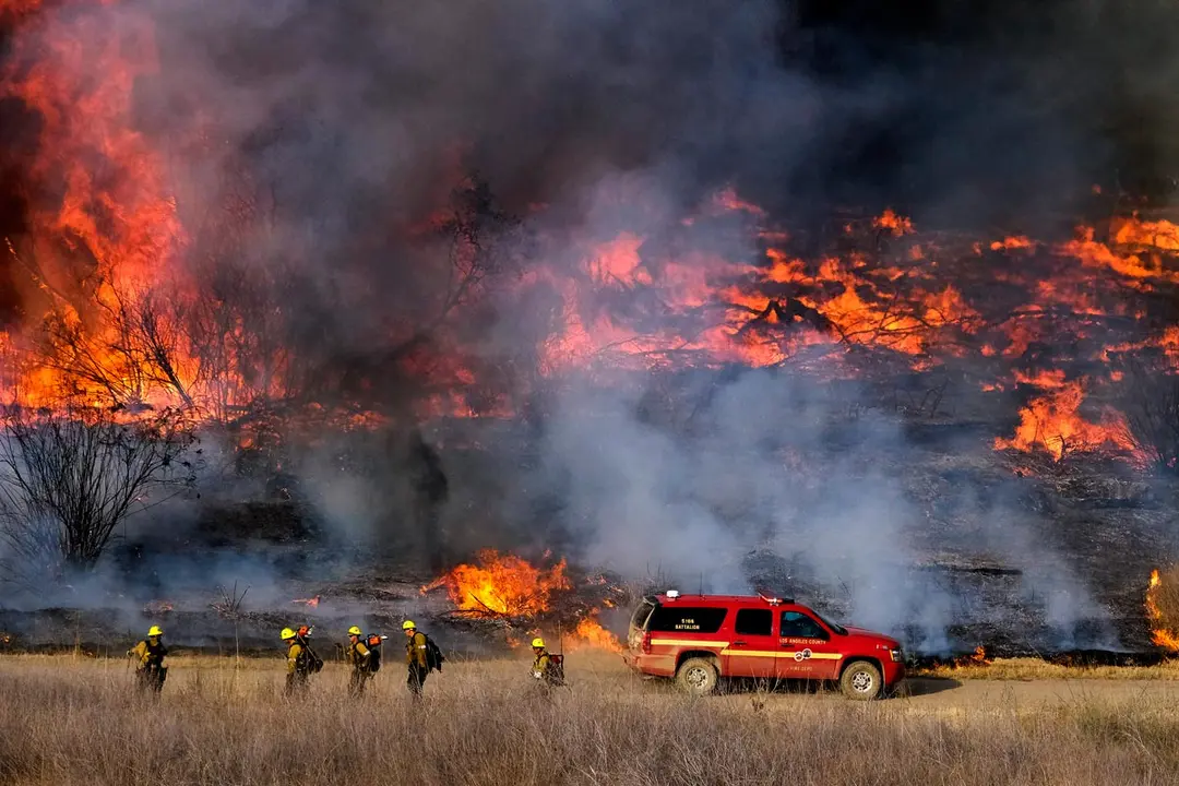 15 June 2021, US, Los Angeles: Firefighters battle brush fire burning in the Santa Fe Dam Recreation Area. Photo: Ringo Chiu/ZUMA Wire/dpa